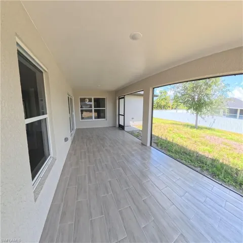 Expansive screened lanai featuring wood-finish tile flooring and an overhead recessed light