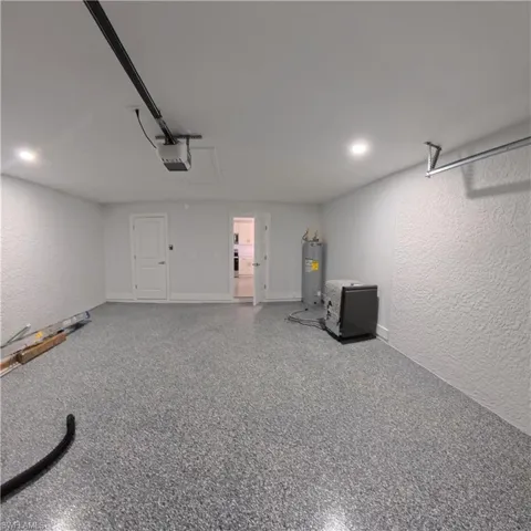 Garage featuring durable epoxy flooring, recessed lighting, and a garage door opener system