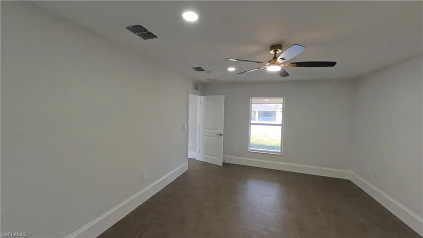Spacious room with neutral wall tones and tile flooring