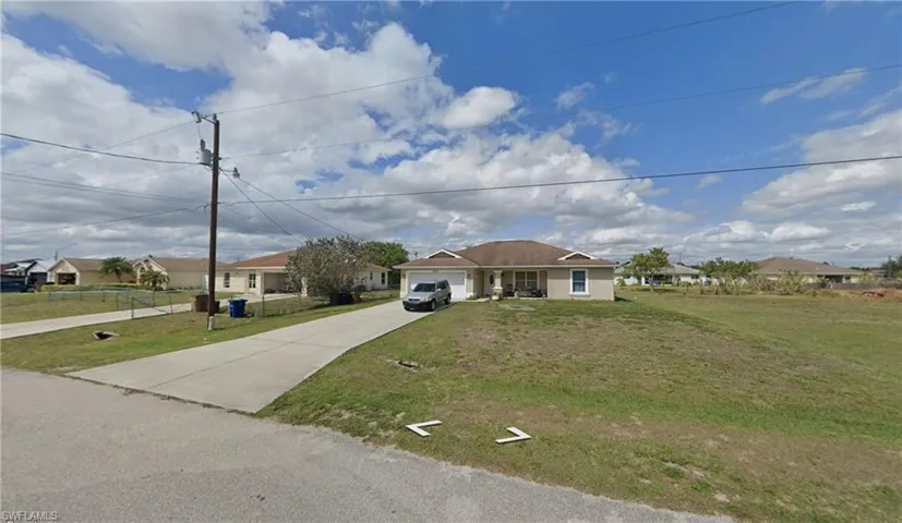 View of front of home featuring a residential view, an attached garage, and driveway