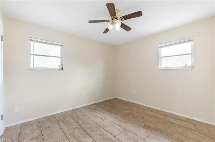 Empty room featuring healthy amount of natural light and a ceiling fan