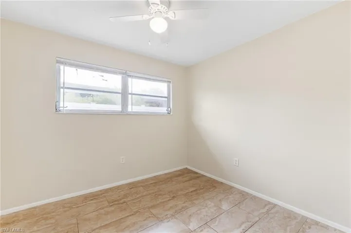 Empty room with ceiling fan and baseboards