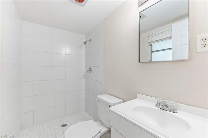 Bathroom with vanity and tiled shower