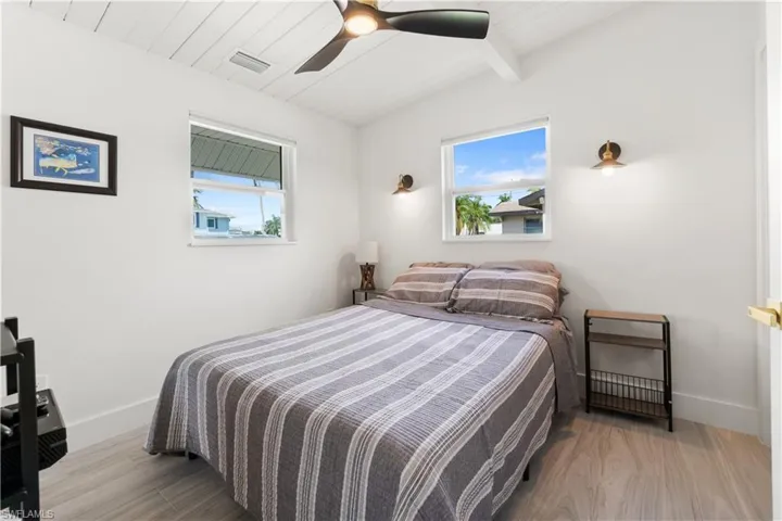 Bedroom with multiple windows, wood ceiling, ceiling fan, and light hardwood / wood-style floors