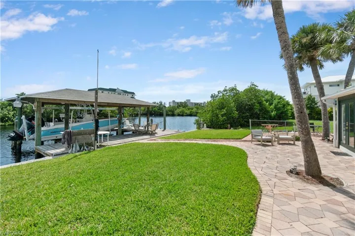 Dock area featuring a water view, a yard, and a patio area