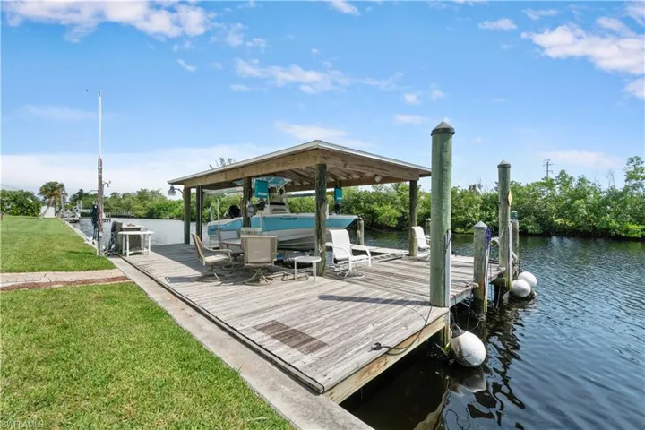Dock area with a water view and a yard