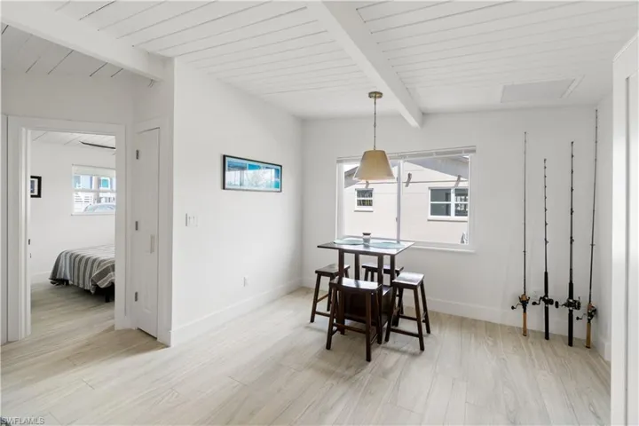 Dining area featuring beam ceiling and light hardwood / wood-style flooring