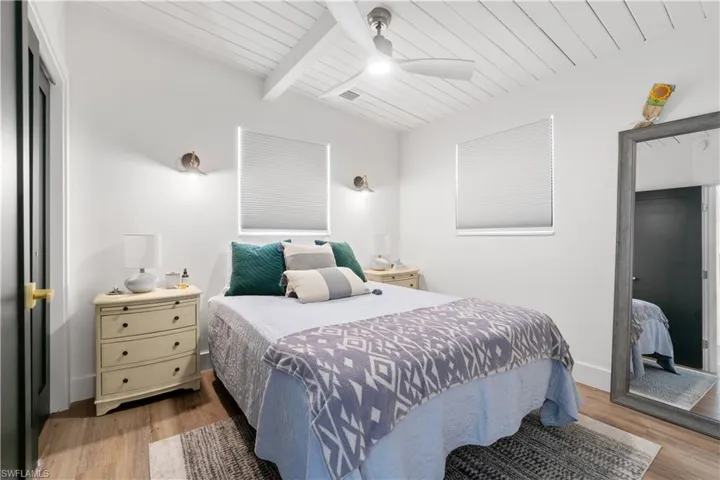 Bedroom featuring vaulted ceiling with beams, light hardwood / wood-style flooring, a closet, and ceiling fan