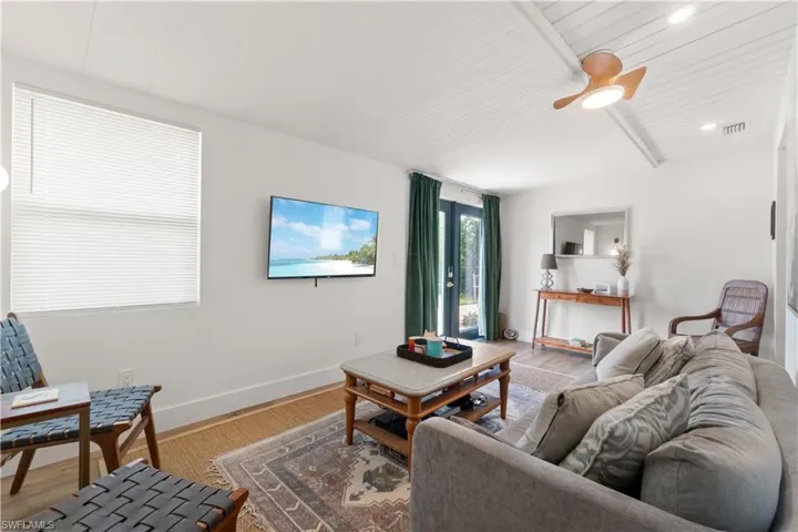 Living room with hardwood / wood-style flooring, wood ceiling, and beam ceiling
