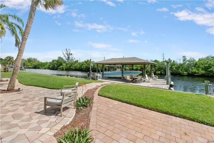 View of community featuring a yard, a dock, and a water view