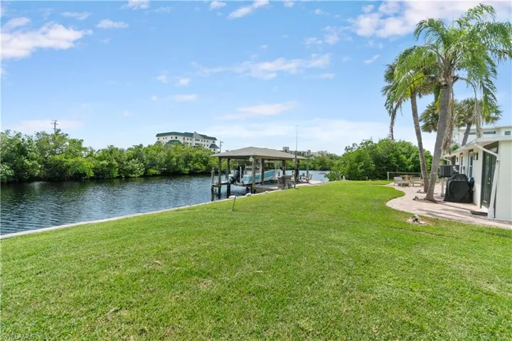 Dock area with a yard and a water view