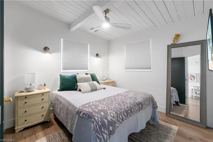 Bedroom featuring vaulted ceiling with beams, hardwood / wood-style floors, wooden ceiling, and ceiling fan