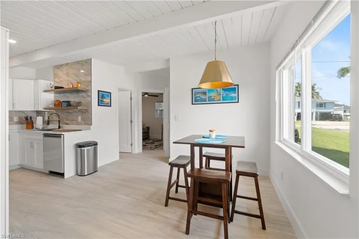 Dining area featuring beamed ceiling, light hardwood / wood-style floors, and sink