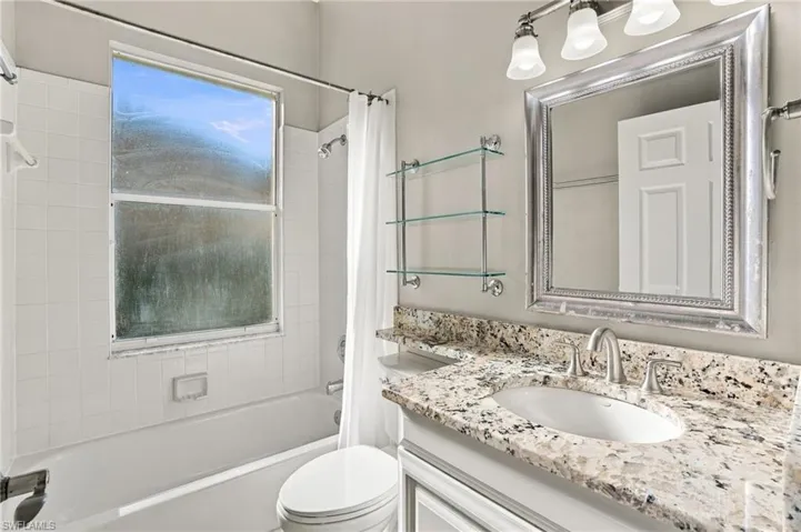 Guest bathroom with granite counter and a tub/shower combo