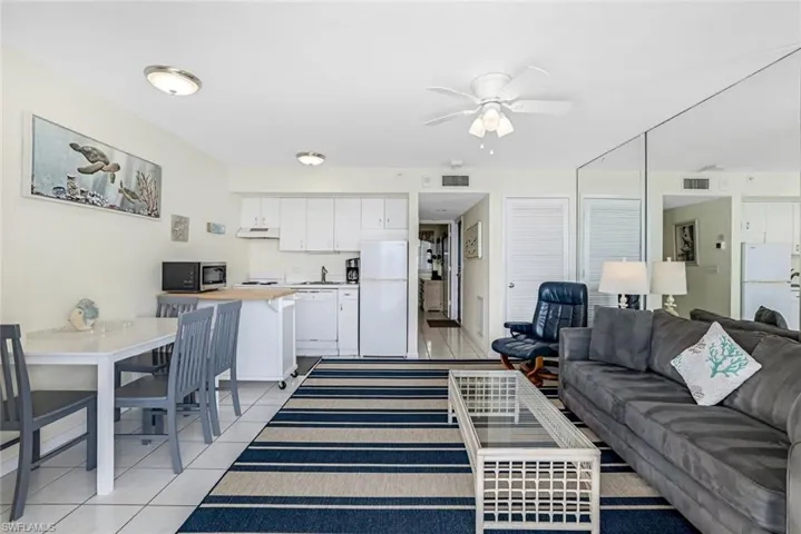 Living area with ceiling fan and light tile patterned flooring