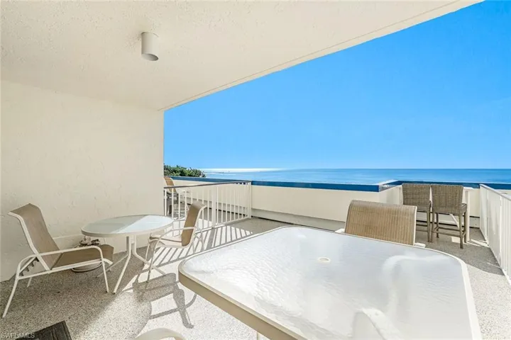 Balcony featuring outdoor dining area and a water view