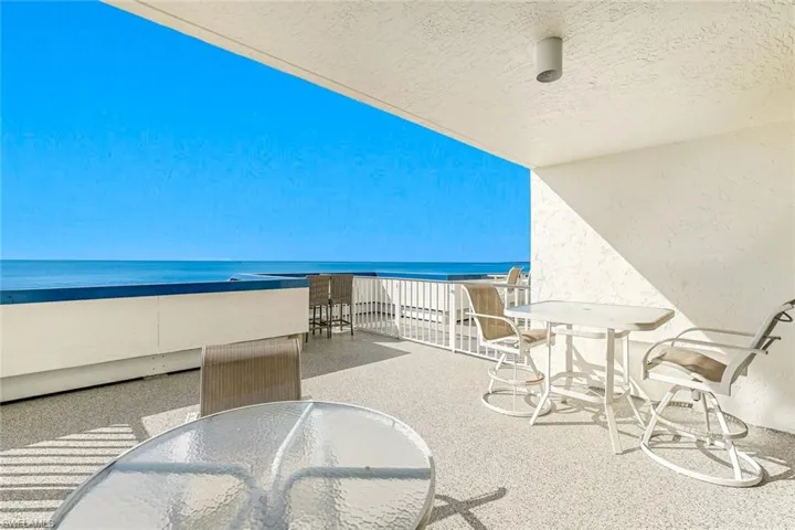 Balcony featuring outdoor dining space and a water view