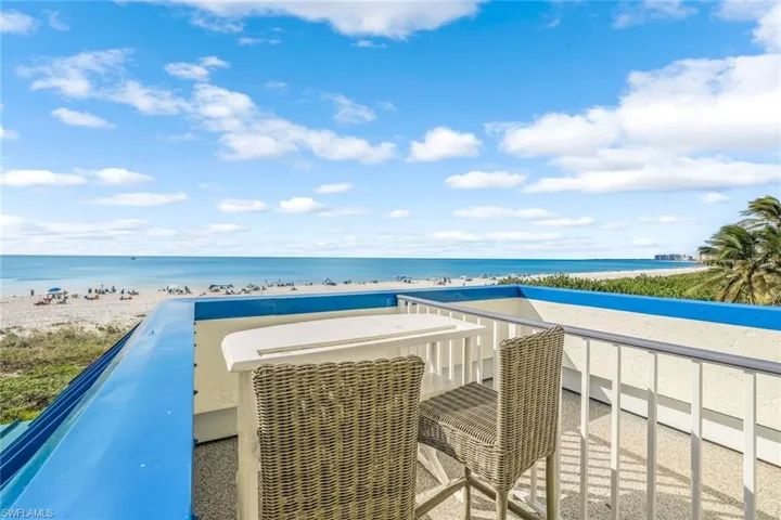 Balcony featuring view of water and beach
