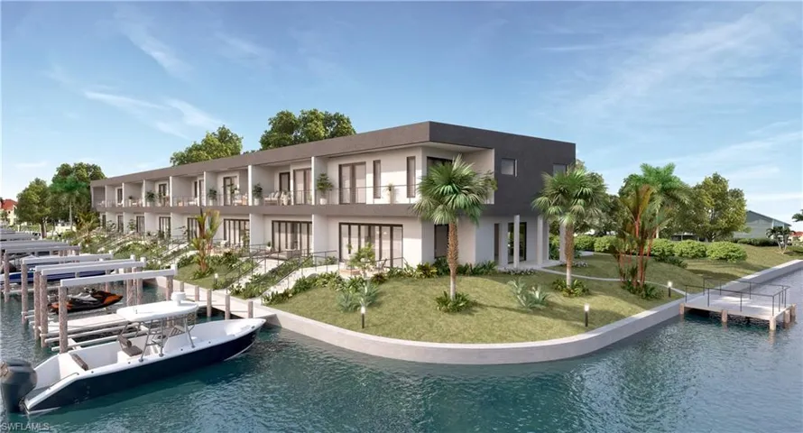 Rear view of house with a yard, stucco siding, a water view, and boat lift