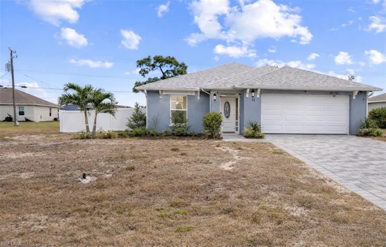 Single story home with stucco siding, a garage, and decorative driveway