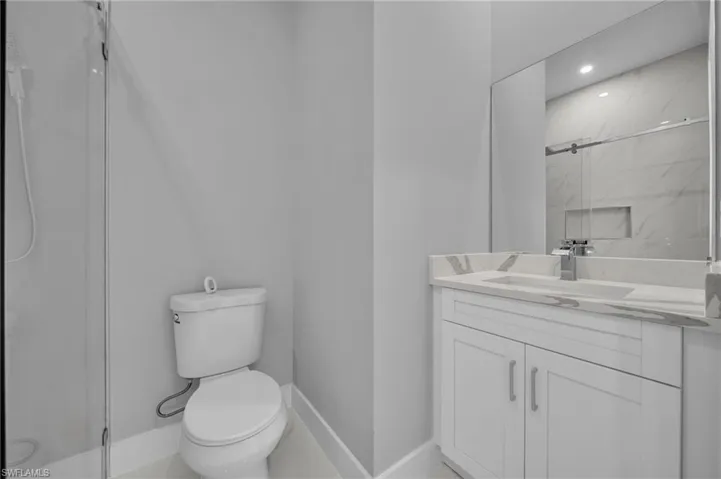 Full bath with a marble finish shower and vanity