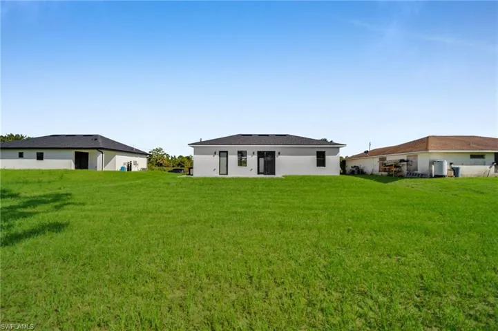 Back of property with a lawn