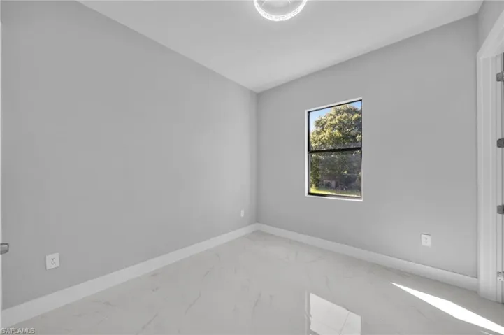 Unfurnished room with baseboards and marble finish floors