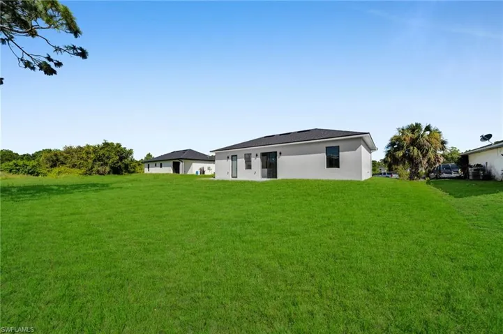 Rear view of house with a yard and stucco siding