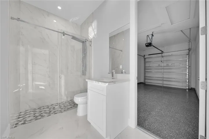 Full bathroom featuring vanity and a marble finish shower