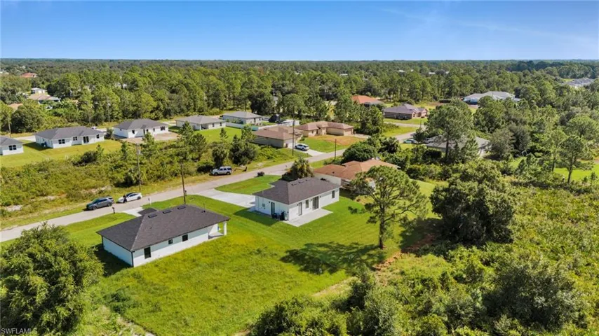 Aerial perspective of suburban area featuring a heavily wooded area