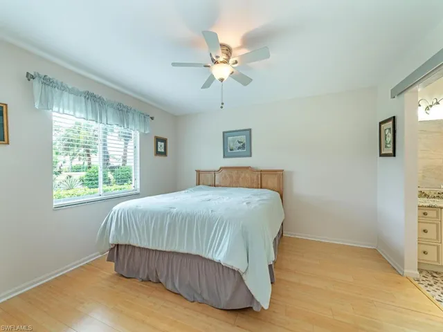 Bedroom featuring connected bathroom, ceiling fan, and light wood-type flooring