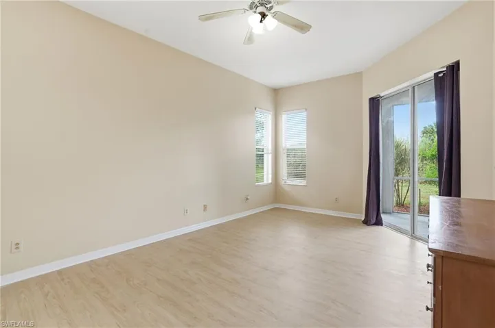 Empty room featuring light wood-style floors and a ceiling fan - Virtually Edited Image