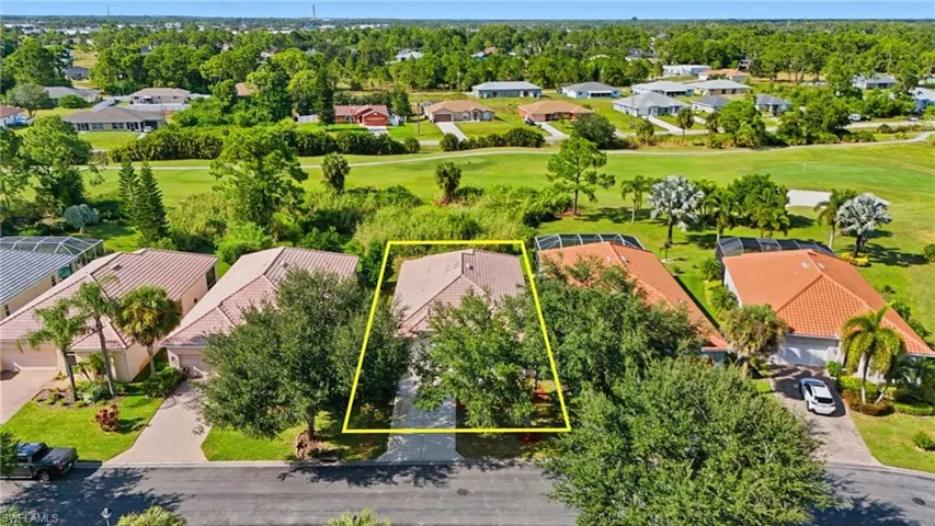 Aerial view of residential area with a golf course and property boundaries highlighted - Virtually Edited Image