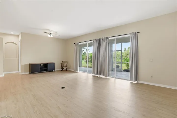 Unfurnished living room with light wood-type flooring and a ceiling fan - Virtually Edited Image