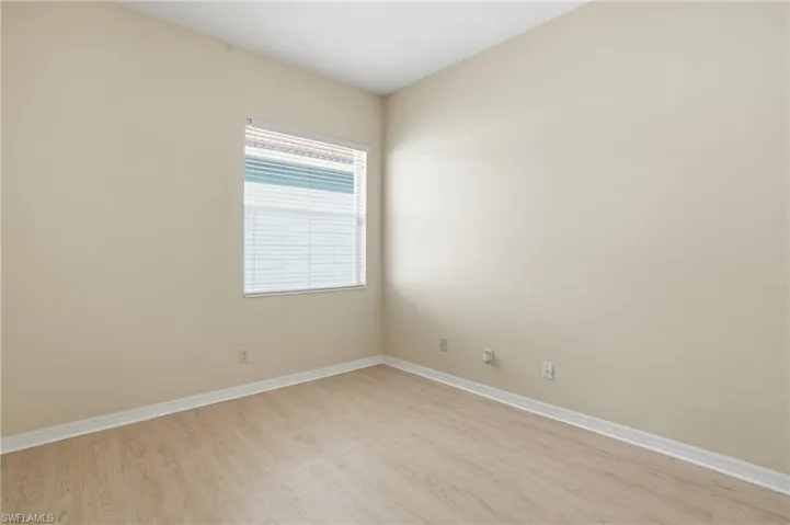 Unfurnished room featuring light wood-type flooring and baseboards - Virtually Edited Image
