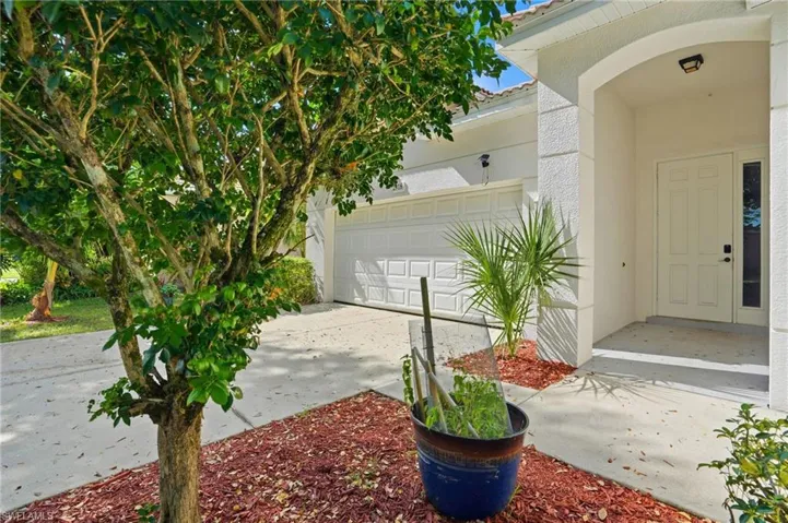 Entrance to property featuring driveway and stucco siding - Virtually Edited Image