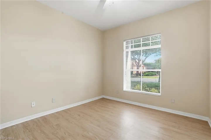 Unfurnished room with light wood-style floors and a ceiling fan - Virtually Edited Image