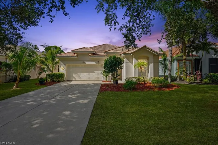 Mediterranean / spanish home with a tiled roof, concrete driveway, stucco siding, and a yard - Virtually Edited Image