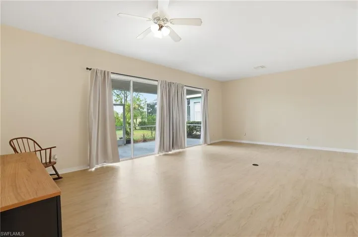 Empty room with light wood-style flooring and ceiling fan - Virtually Edited Image