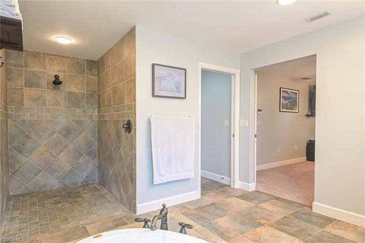 View of oversized walk in shower, water closet and door to master suite.