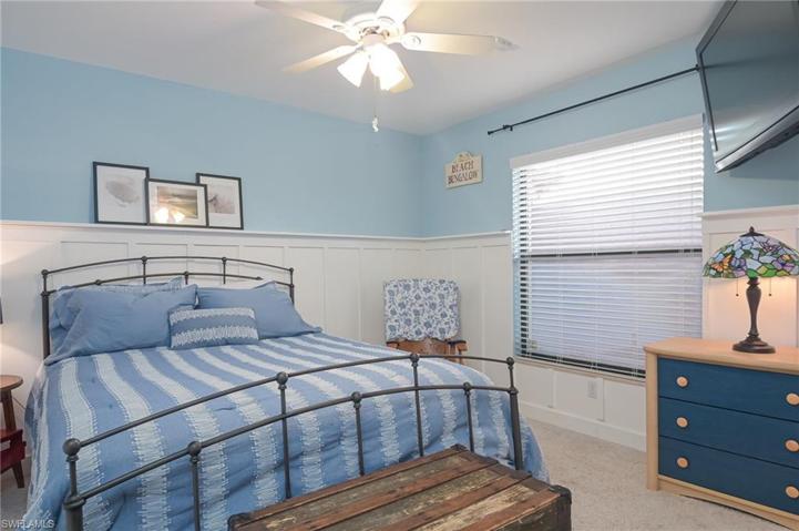 Guest bedroom with large window and custom wood accent walls.