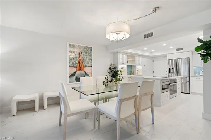 Dining room featuring light tile floors, recessed lighting, and a chandelier
