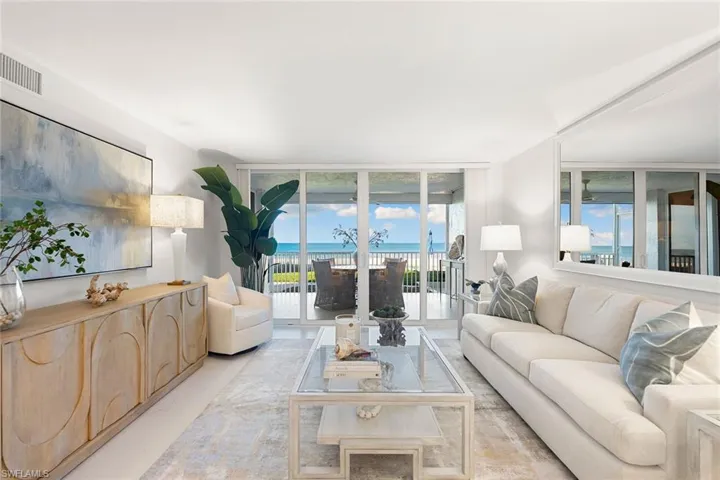 Living room featuring expansive windows, tile flooring, and a water view