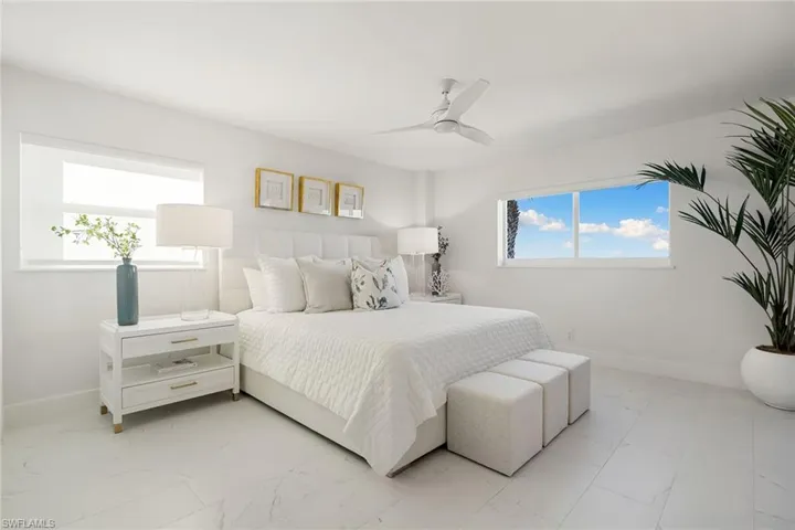 Bedroom featuring a ceiling fan and marble look tile flooring