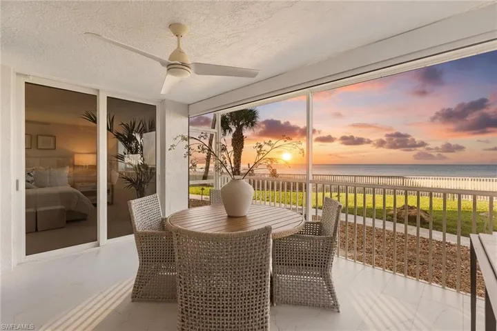 Sunroom featuring a water view, a textured ceiling, and expansive windows