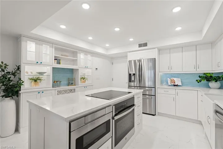 Kitchen featuring white cabinetry, stainless steel appliances, light marble finish flooring, recessed lighting, and open shelves