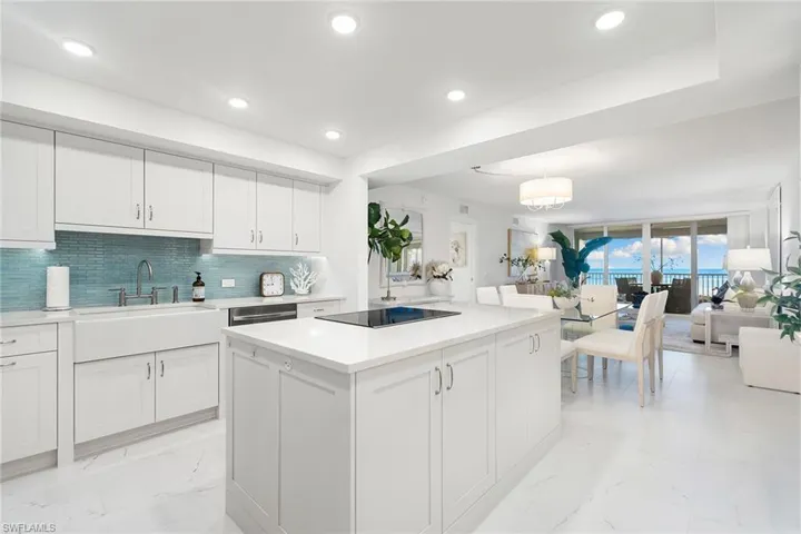 Kitchen featuring white cabinets, decorative light fixtures, a kitchen island, decorative backsplash, and recessed lighting