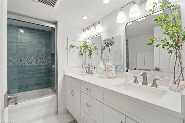 Full bath featuring double vanity, washtub / shower combination, and recessed lighting