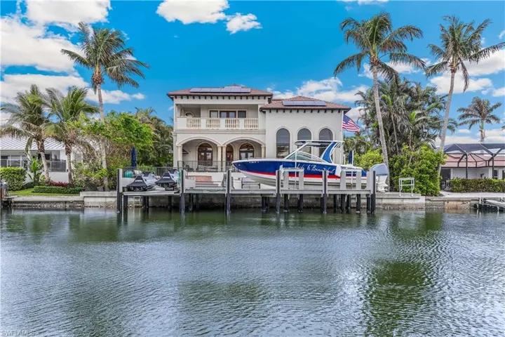 View of dock with a water view and a balcony