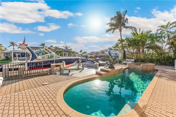 View of swimming pool featuring an in-ground hot tub and a boat dock